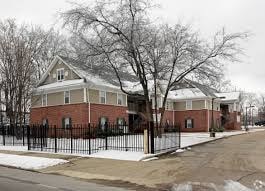 A brick house with a black fence in front.