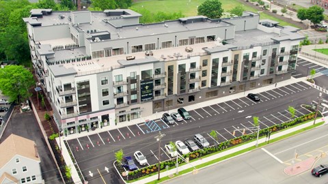 A parking lot in front of a multi-story building.
