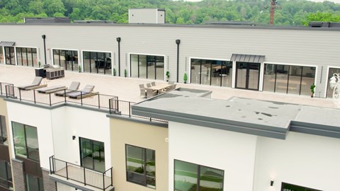 Apartment complex with balconies and a view of trees.