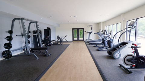 A spacious gym with a variety of equipment including treadmills, weights, and exercise bikes.
