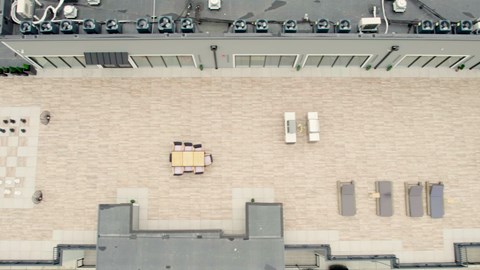 A parking lot with cars and a building with a window and air conditioning unit.