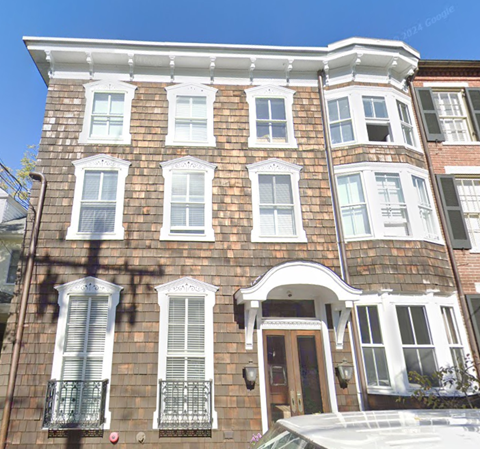 A brown brick house with white trim and windows.