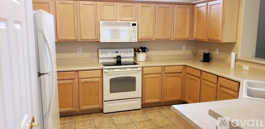 A kitchen with wooden cabinets and a white refrigerator.