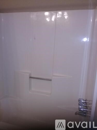 A white bathroom with a towel rack and a white door.