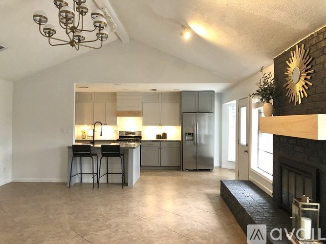 A modern kitchen with a bar stool and a fireplace.