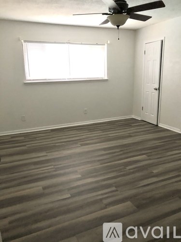 A room with a ceiling fan and a door.