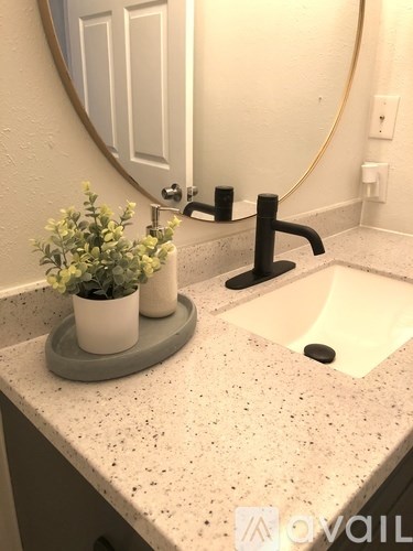 A bathroom sink with a round mirror above it.