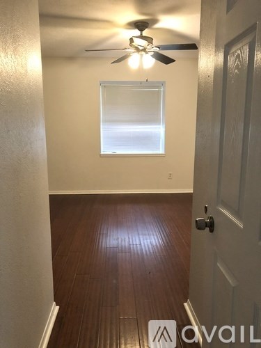 A room with a ceiling fan and a door.