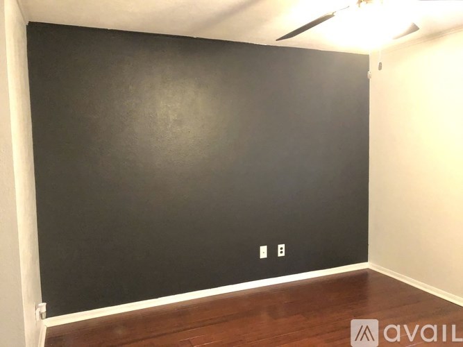 A room with a dark wall and a light switch.