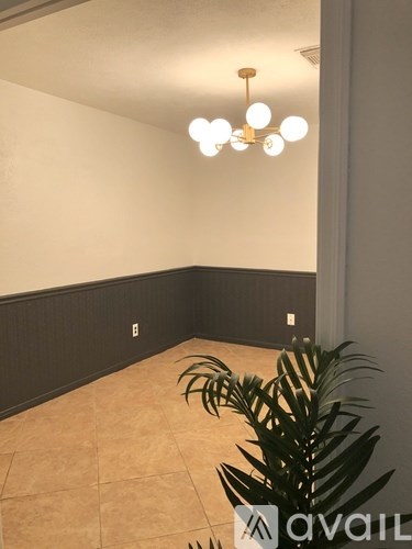 A room with a plant and a chandelier.