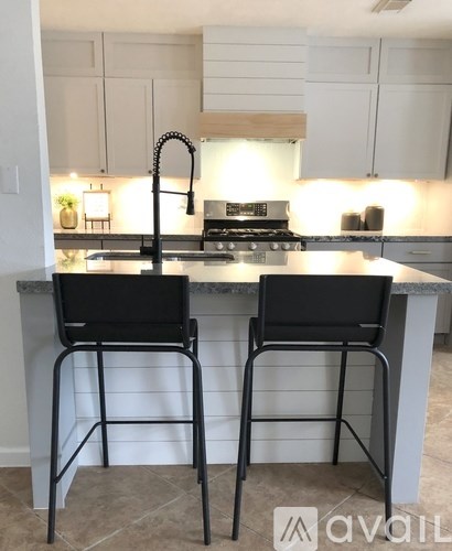 Two black chairs are placed in front of a kitchen island.