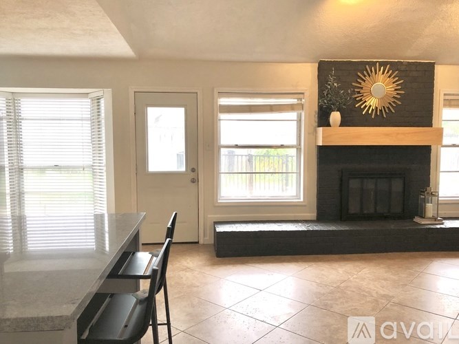 A living room with a fireplace and a dining table.