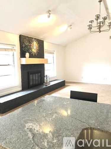 A living room with a fireplace and a chandelier.