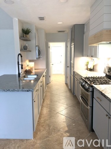 A kitchen with a white fridge and a white door.