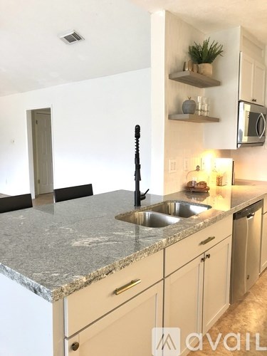 A kitchen with a granite countertop and white cabinets.
