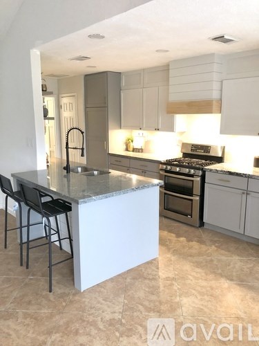 A kitchen with a marble countertop and a sink.