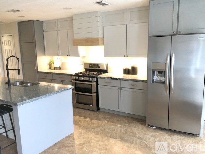 A modern kitchen with stainless steel appliances and white cabinets.