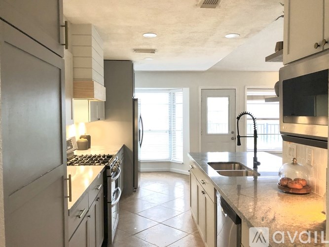 A kitchen with a sink, stove, and refrigerator.