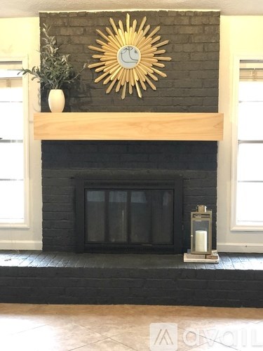 A fireplace with a sun design on the wall above it.
