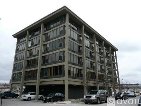 A large, multi-story building with a parking lot in front.