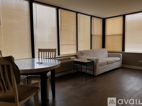 A living room with a table, chairs, and a couch.