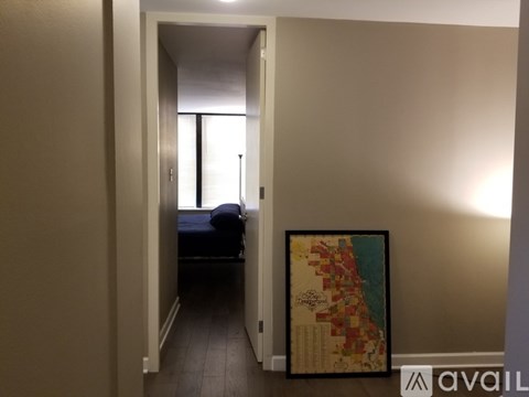 A room with a bed and a framed map on the wall.