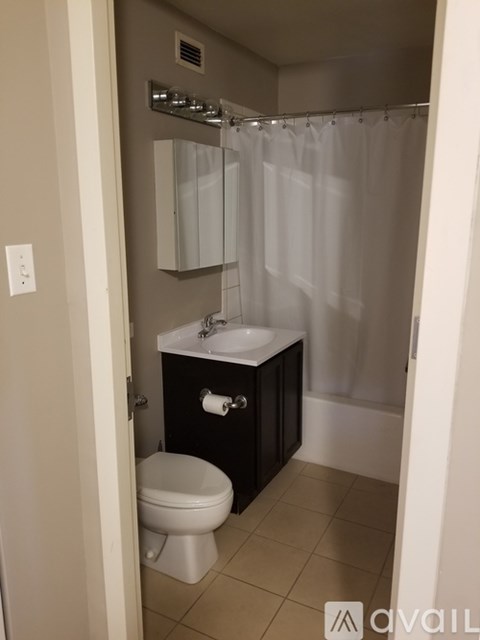A bathroom with a toilet, sink, and shower.