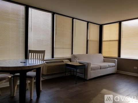 A living room with a table, chairs, and a couch.