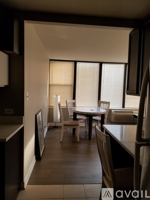A kitchen with a table and chairs in front of a window.