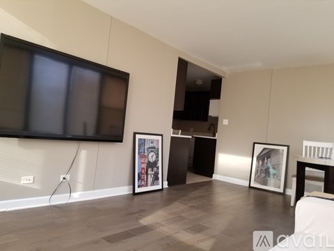 A living room with a television, a cabinet, and two pictures on the wall.