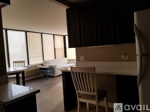 A living room with a couch, chair, and a dining table.