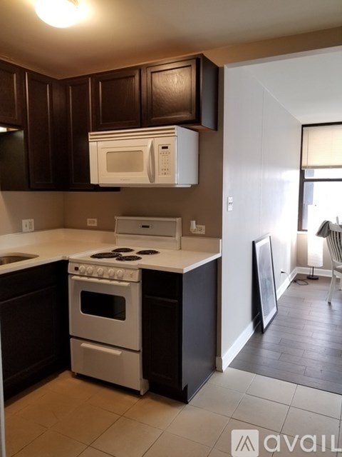 A kitchen with a white stove and microwave above it.