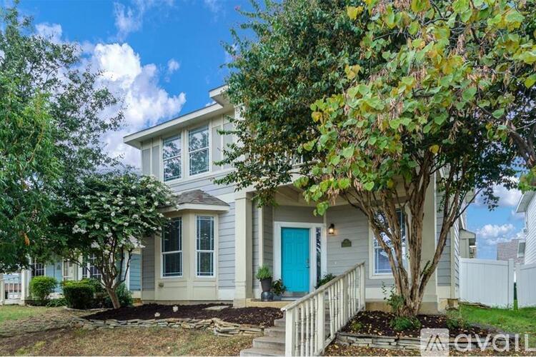 A house with a blue door and white trim is for sale.