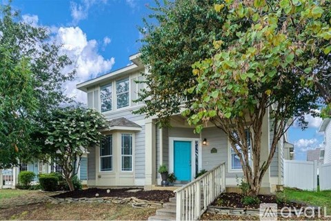 A house with a blue door and white trim is for sale.