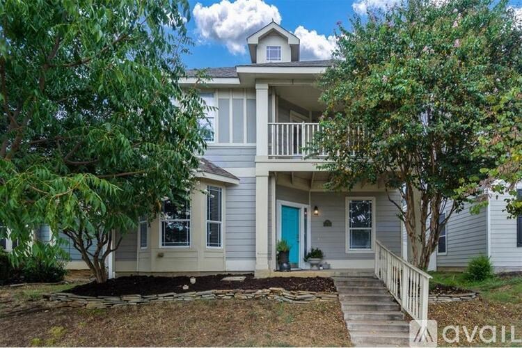 A house with a blue door and a tree in front.