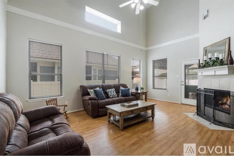 A living room with a brown leather couch and a wooden coffee table.