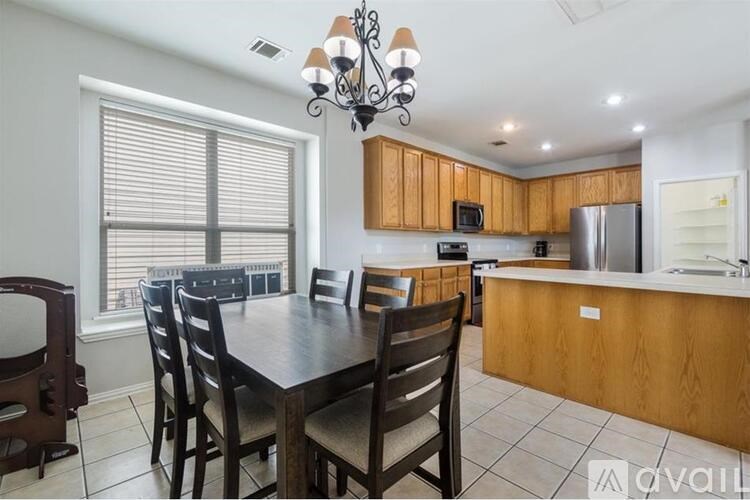 A kitchen with a table and chairs in front of a window.