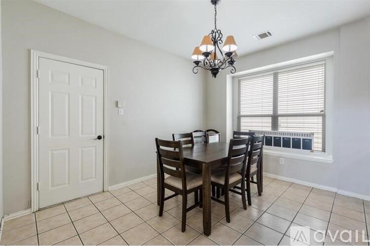 A dining room with a table and chairs.