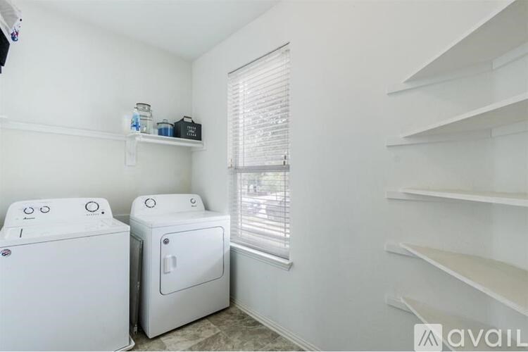 A small room with two white appliances and a window.
