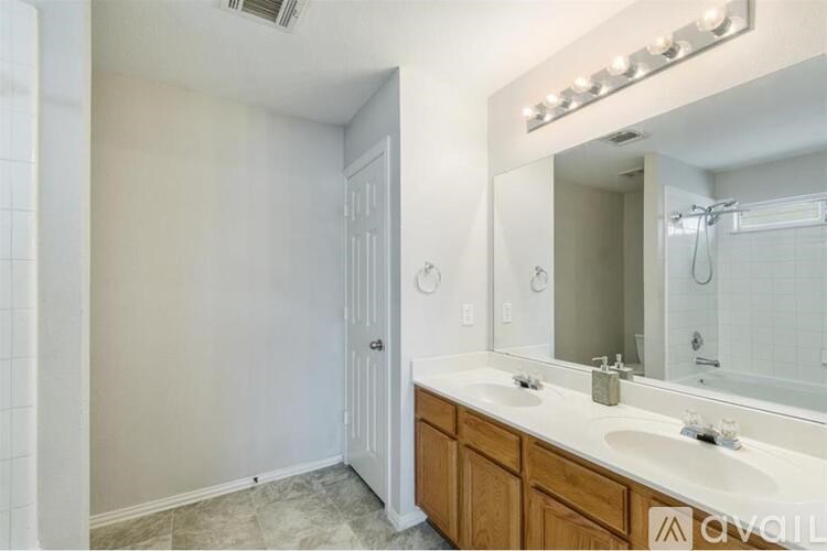 A bathroom with a vanity, mirror, and a shower.