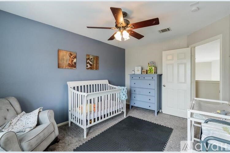 A baby room with a white crib and a grey dresser.