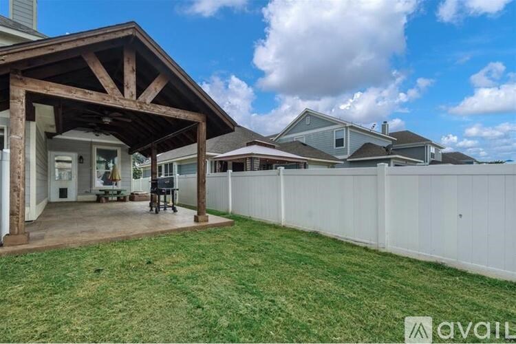 A house with a covered patio and a white fence.