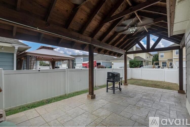 A patio with a table and chairs under a roof.