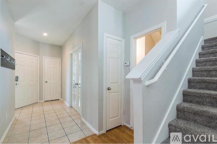A hallway with a staircase leading to the second floor.