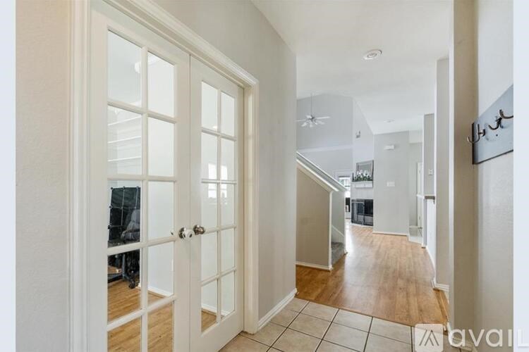 A hallway with a white door and a tiled floor.