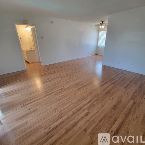 A room with wooden flooring and a ceiling fan.
