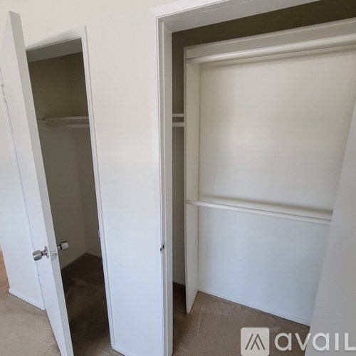 A white door is open to a room with a white wall.