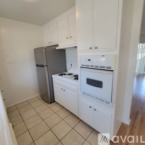 A kitchen with white cabinets and appliances.