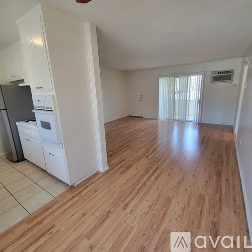 A kitchen with white cabinets and a refrigerator.