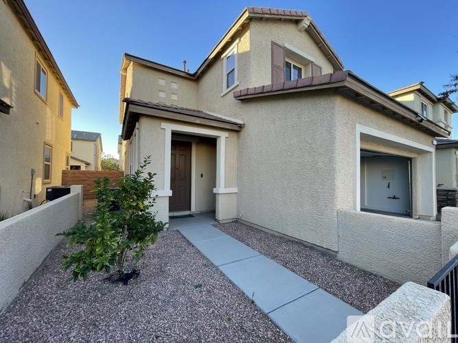 A beige house with a brown roof and a brown door.